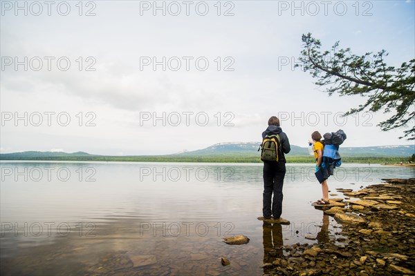 Caucasian couple backpacking near rural lake