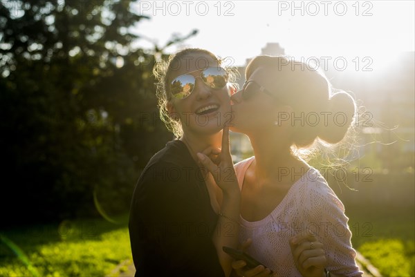 Caucasian women kissing in backyard