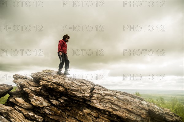 Caucasian woman climbing rock formation