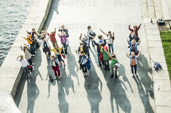 High angle view of Caucasian children waving from waterfront