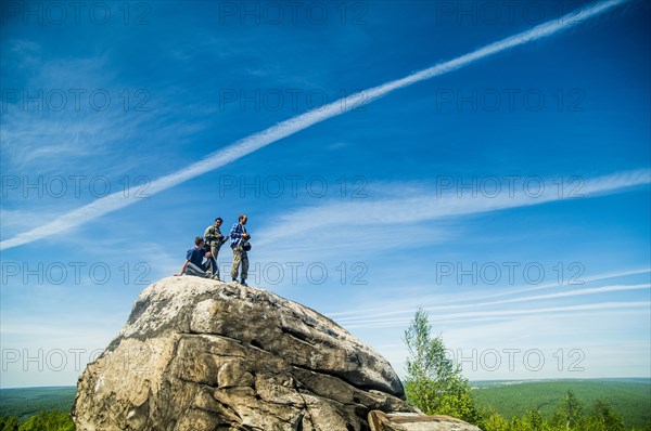 Caucasian climbers standing on rock formation