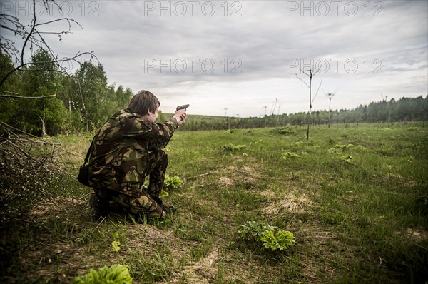 Caucasian man practicing shooting in rural field