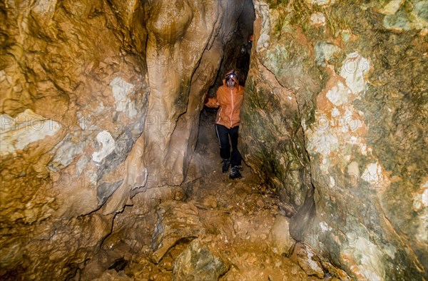 Caucasian woman exploring rock formation cave