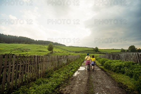 Caucasian couple walking on rural dirt road