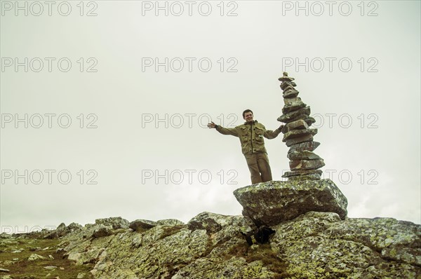 Caucasian boy smiling near stack of rocks