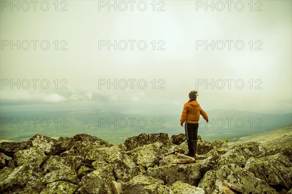 Caucasian hiker enjoying scenic view from rocky hilltop