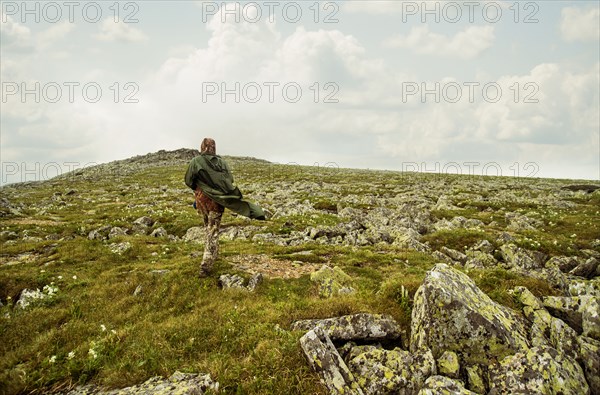 Caucasian hiker walking on rocky hillside