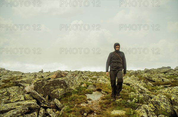 Caucasian hiker walking on rocky hillside