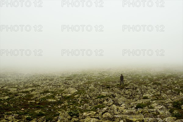 Caucasian hiker walking in rocky field
