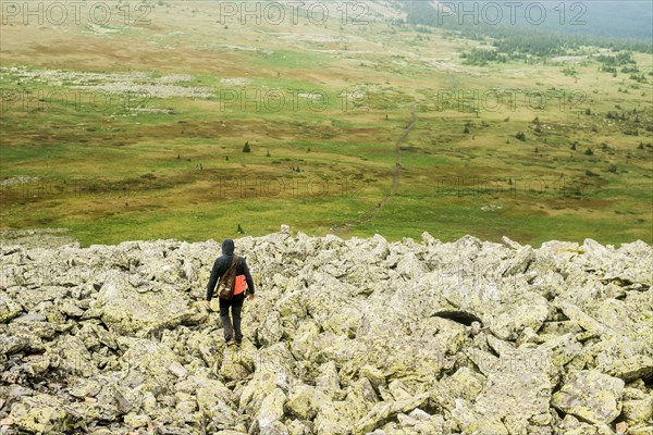 Caucasian hiker walking in rocky field