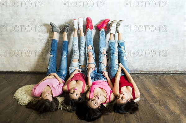 Caucasian women laying on floor with feet on wall