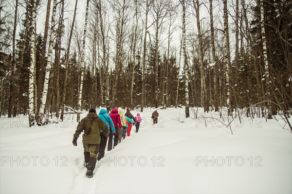 Caucasian hikers walking in snowy forest