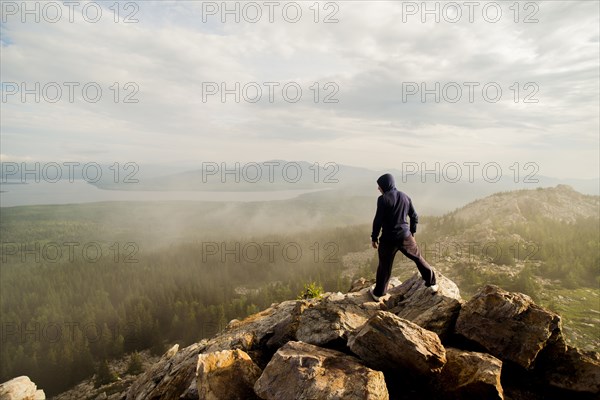 Caucasian hiker standing on rocky hilltop