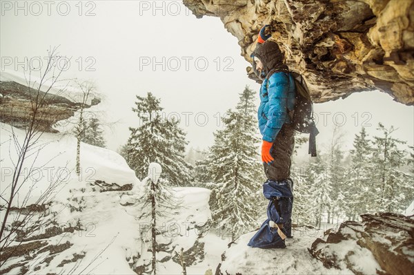 Caucasian hiker standing on snowy rock formations