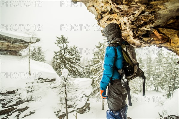 Caucasian hiker standing on snowy rock formations