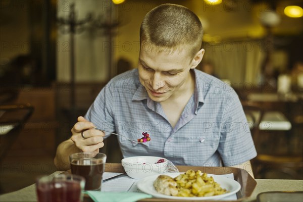 Caucasian man eating lunch at table