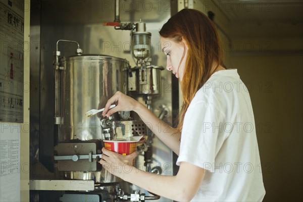 Caucasian woman pouring hot water into bowl