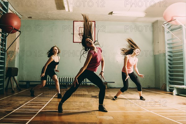 Caucasian dancers rehearsing in gym