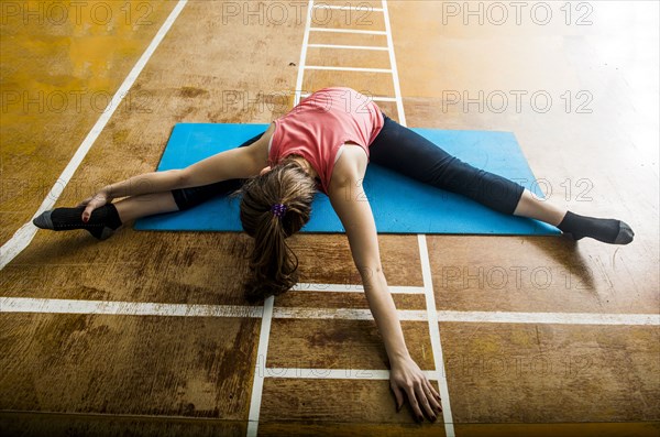 Caucasian dancer stretching in gym