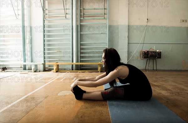 Caucasian dancer stretching in gym