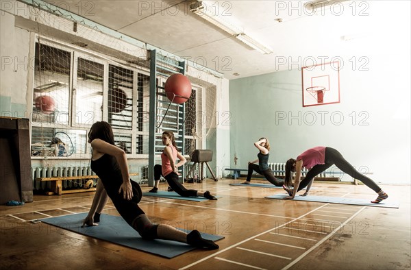 Caucasian dancers stretching in gym