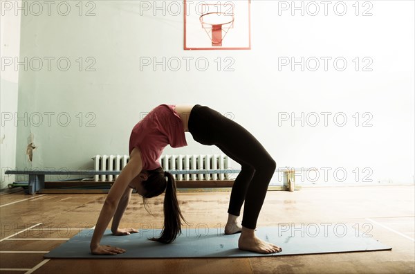Caucasian dancer stretching and balancing in gym