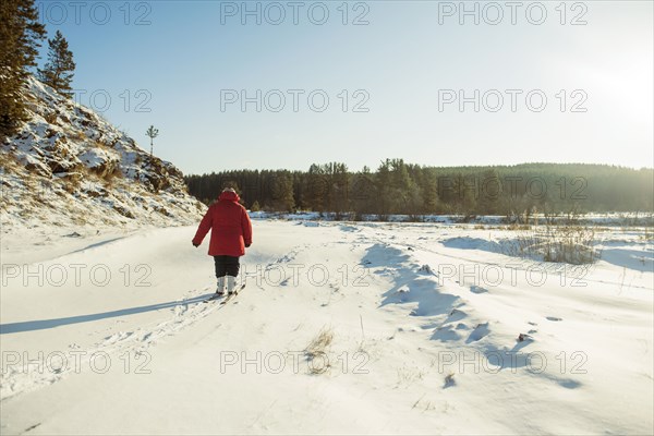 Caucasian woman cross-country skiing in snowy field