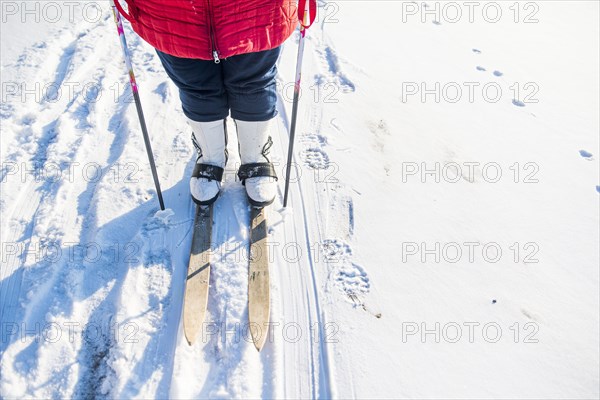 Caucasian woman cross-country skiing in snowy field