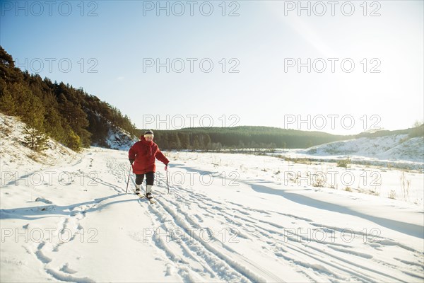 Caucasian woman cross-country skiing in snowy field