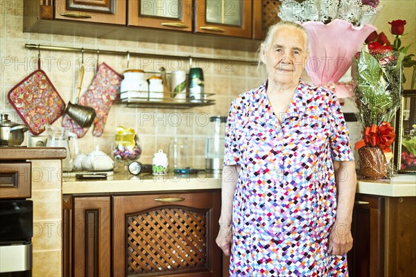 Older Caucasian woman standing in kitchen