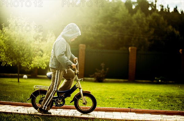 Caucasian boy riding bicycle in backyard