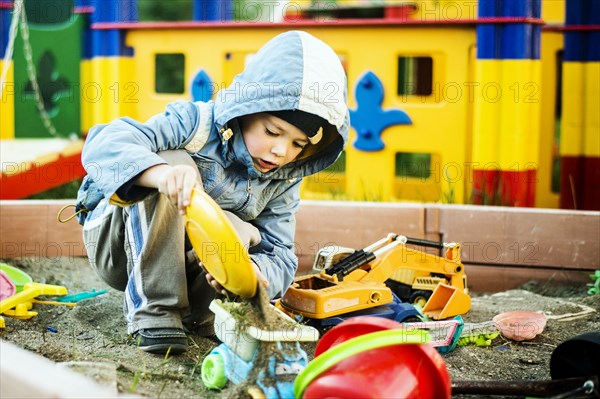 Caucasian boy playing in sandbox