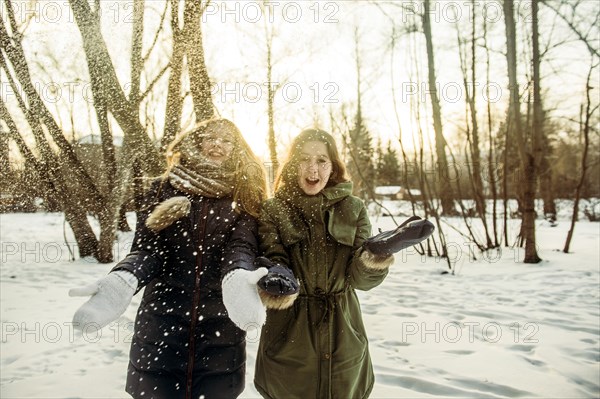 Caucasian women playing in snowy field