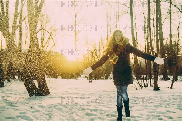 Caucasian woman playing in snowy field