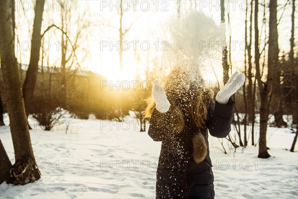 Caucasian woman playing in snowy field