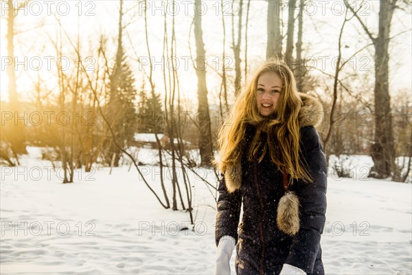 Caucasian woman playing in snowy field