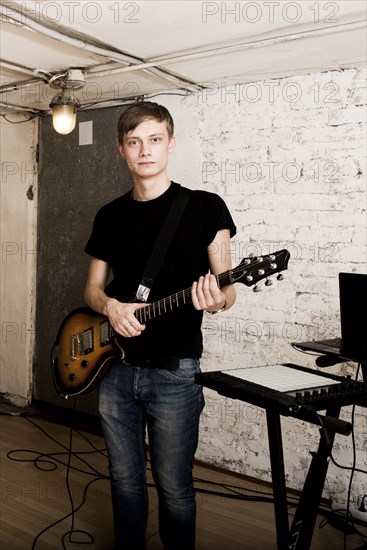 Caucasian man playing electric guitar in rock band