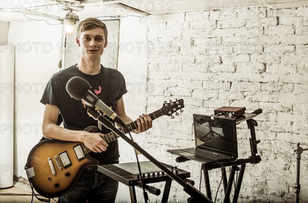 Caucasian man playing electric guitar in rock band