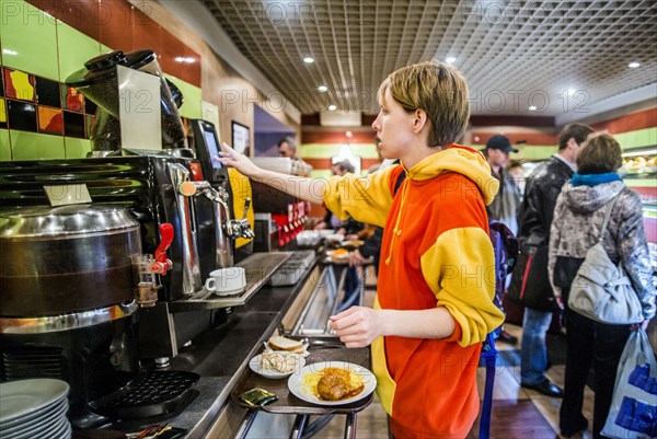 Caucasian woman getting breakfast in cafeteria