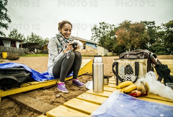 Caucasian woman admiring photographs at picnic