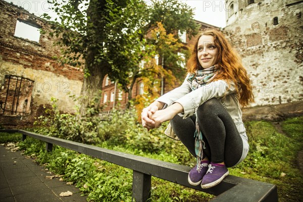 Caucasian woman crouching on wooden banister