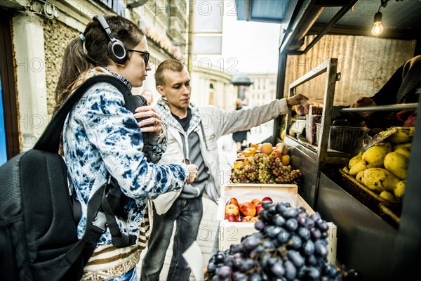 Caucasian couple buying produce at fruit kiosk