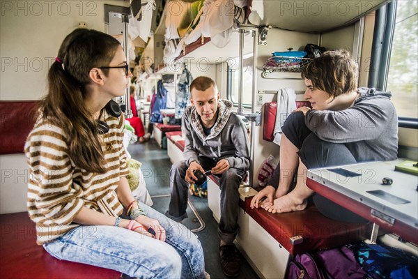 Caucasian friends talking in train on road trip