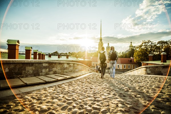 Caucasian tourists walking on cobblestone Leningrad street