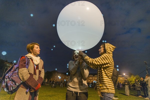 Caucasian friends playing with balloon in park