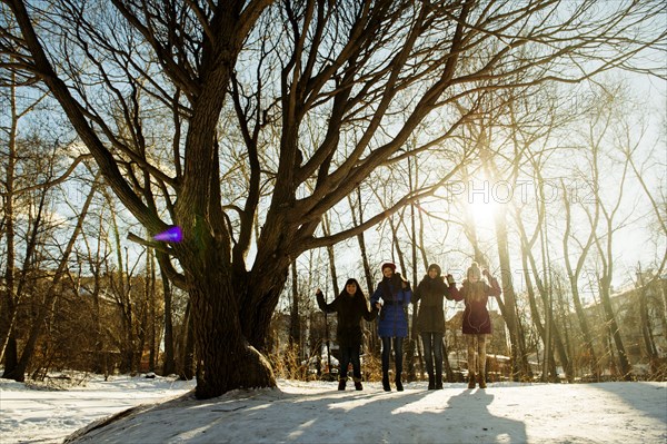 Caucasian girls standing neat tree in snowy field