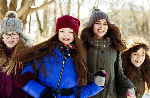 Caucasian girls arm in arm outdoors in winter