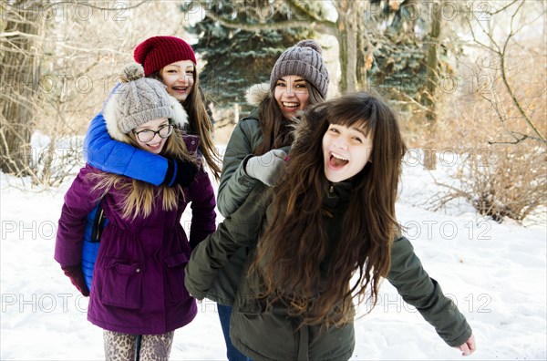 Caucasian girls playing in snowy field