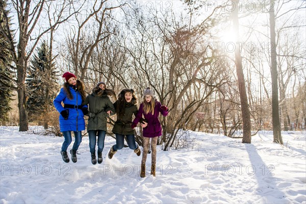 Caucasian girls playing in snowy field