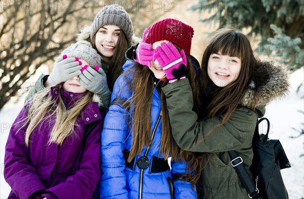 Caucasian girls playing in snowy field